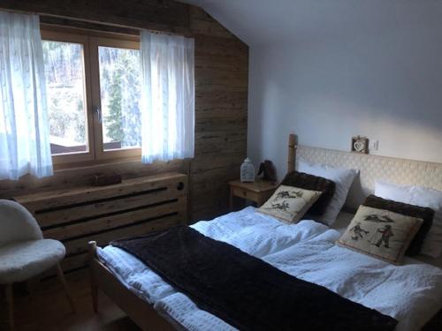 a bedroom with a large bed and a window at The cosy Isba - Chambre d hôtes - Val de Bagnes - Verbier in Versegeres 