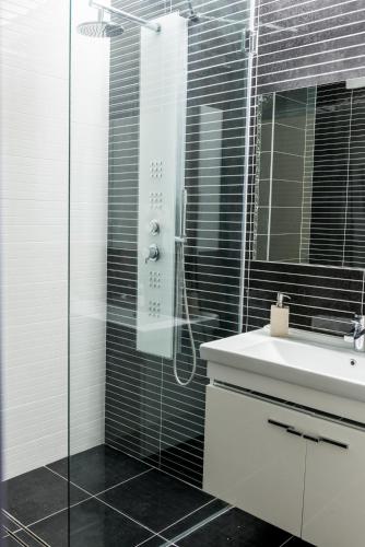 a bathroom with a sink and a glass shower at Hotel On Plonge Junior in Mamaia