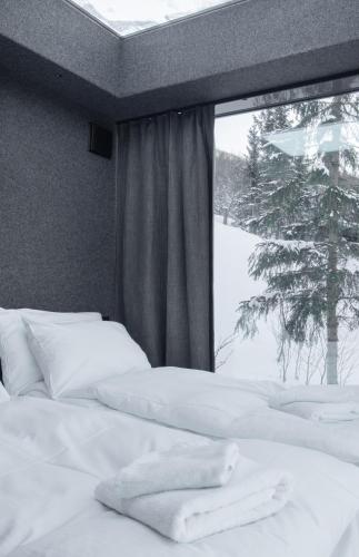 une chambre avec deux lits blancs et une fenêtre dans l'établissement NARVIKFJELLET Camp 291, à Narvik