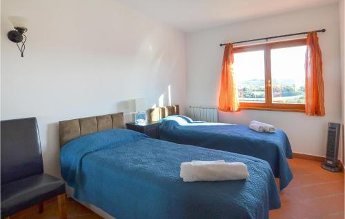 a bedroom with two beds and a chair and a window at Beautiful Apartment In Bucine With Outdoor Swimming Pool in Bucine