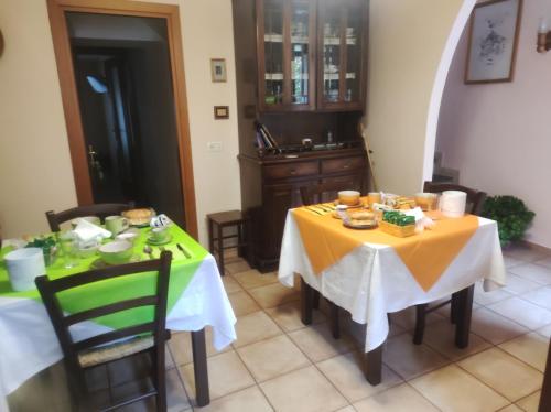 ein Esszimmer mit 2 Tischen und einem gelben Tischtuch in der Unterkunft La Loggetta in Bagnoregio