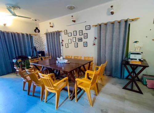 a dining room with a wooden table and chairs at THEHIMALAYANLIVING WHISTLING PINES in Mukteswar