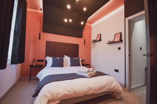 um quarto com paredes cor-de-laranja e uma cama grande em Central Stays - Luxury 3 Bedroom House in Central Chester SLEEPS 6 em Chester