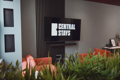 a room with chairs and a tv with the words central stays at Central Stays - Luxury 3 Bedroom House in Central Chester SLEEPS 6 in Chester