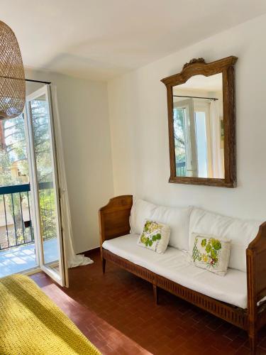 - un salon avec un canapé blanc et un miroir dans l'établissement Charmant T3 au milieu des pins, terrasse sud, vue mer, plage à pieds, fibre et garage privé inclus, aux Lecques