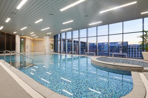 uma grande piscina num edifício com janelas em Nine Tree Premier Hotel Seoul Pangyo em Seongnam