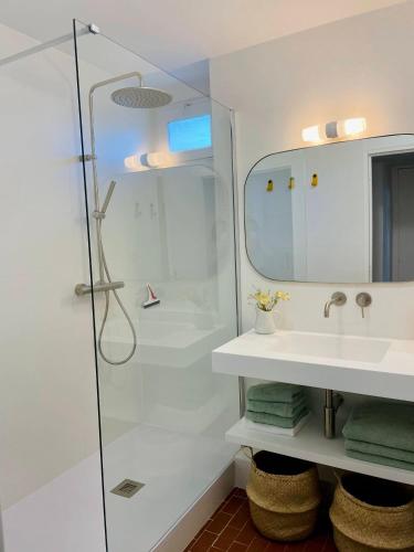 une salle de bain avec une douche, un lavabo et un miroir dans l'établissement Charmant T3 au milieu des pins, terrasse sud, vue mer, plage à pieds, fibre et garage privé inclus, aux Lecques