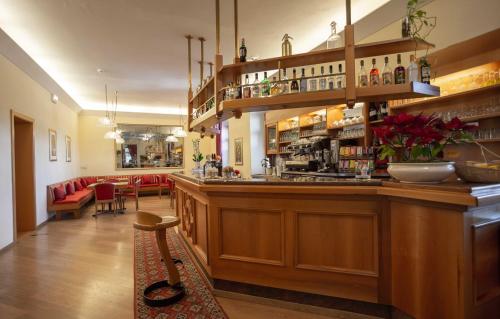a bar in a restaurant with a table and chairs at Hotel Salegg in Siusi