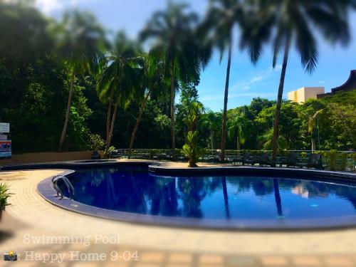a swimming pool with palm trees in a resort at Happy Home 26 Sri Sayang Batu Ferringhi in Batu Ferringhi