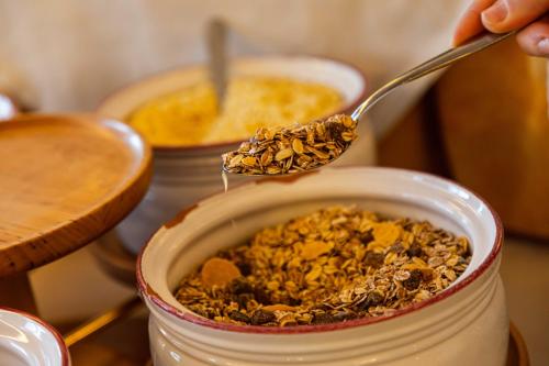 a person holding a spoon over a jar of granola at Hotel Salegg in Siusi