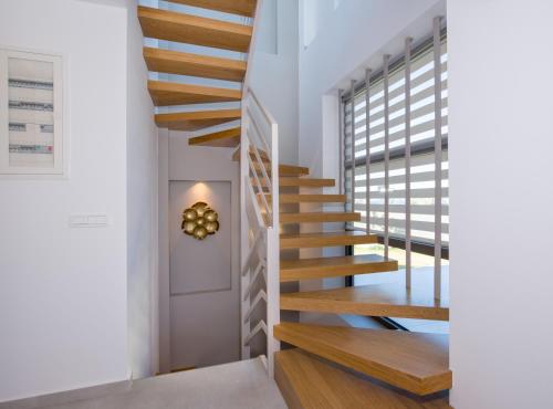 a staircase with wooden treads in a house at Imperium Luxury Villas-Sauna, Jacuzzi, Heated Pool & Gym-Chania in Kato Galatas