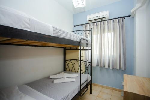 two bunk beds in a room with a window at Tsampika's Sea View Home in Archangelos