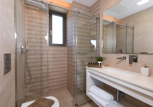 a bathroom with a glass shower and a sink at Imperium Luxury Villas-Sauna, Jacuzzi, Heated Pool & Gym-Chania in Kato Galatas