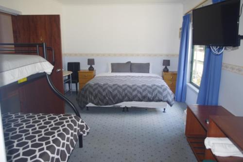sypialnia z łóżkiem i telewizorem z płaskim ekranem w obiekcie The Grand Halls Gap w mieście Halls Gap