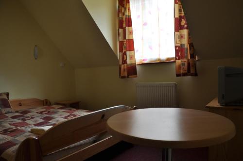 a bedroom with a bed and a table and a window at Privat Podlesom in Kežmarok