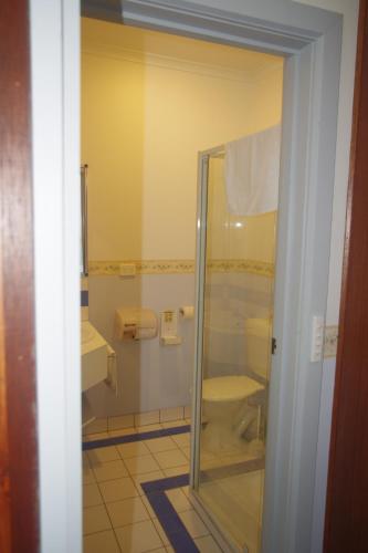 a bathroom with a glass shower and a toilet at Halls Gap Tavern in Halls Gap