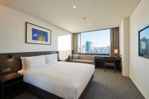 a hotel room with a large bed and a desk at Nine Tree by Parnas Seoul Insadong in Seoul