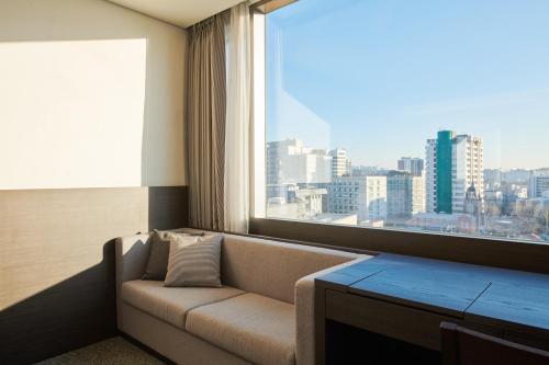 a living room with a couch and a large window at Nine Tree by Parnas Seoul Insadong in Seoul