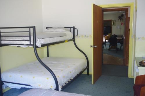 two bunk beds in a room with a doorway at Halls Gap Tavern in Halls Gap