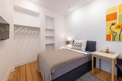 een kleine slaapkamer met een bed en een tafel bij Appartements an der Therme in Bad Ems