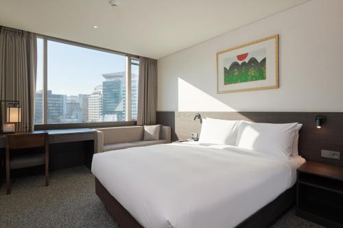 a hotel room with a bed and a desk and a window at Nine Tree by Parnas Seoul Insadong in Seoul