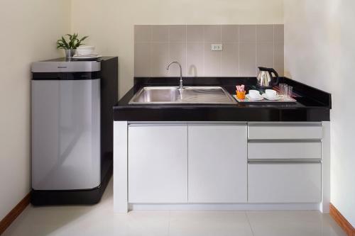 a kitchen with a sink and a counter top at The Plimplace Hotel in Bang Su