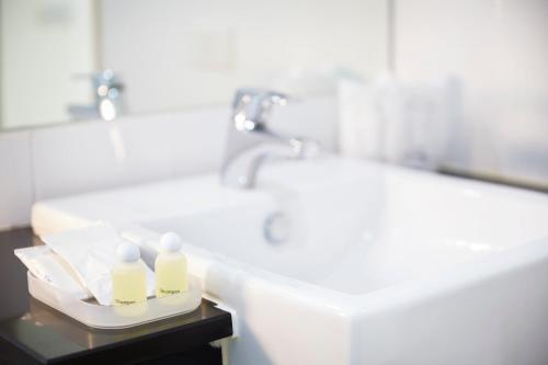 a bathroom with a sink and a toilet and a tub at The Plimplace Hotel in Bang Su