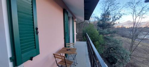a balcony with two chairs and a green door at Eden Guest House Colico in Colico