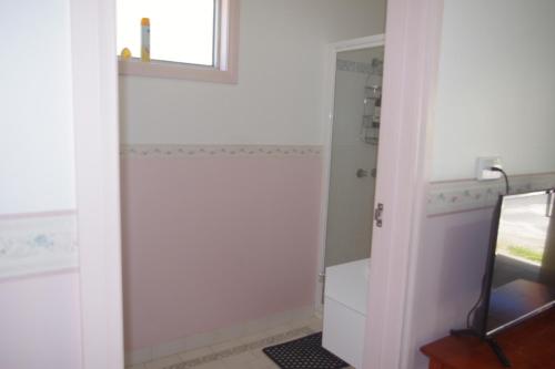 a bathroom with a shower and a white door at Halls Gap Tavern in Halls Gap
