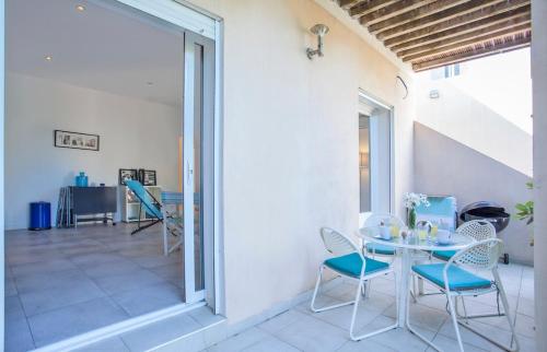 une salle à manger avec une table et des chaises sur un patio dans l'établissement Casa Estel - Blue apartment in downtown of Erbalunga, à Brando