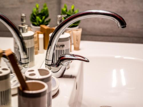 a kitchen sink with a chrome kitchen faucet at Prezydencki Apartamenty z widokiem na morze in Jarosławiec