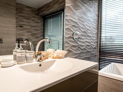 a bathroom with a sink and a mirror at Prezydencki Apartamenty z widokiem na morze in Jarosławiec