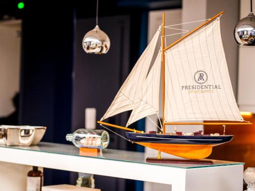 a toy sailboat on a table in a room at Prezydencki Apartamenty z widokiem na morze in Jarosławiec