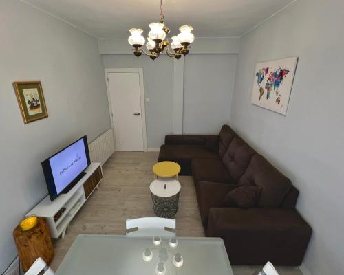 sala de estar con sofá y TV en La Penca del Maguey en Santander