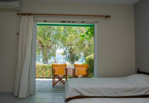 a bedroom with a bed and a sliding glass door at ΑΚΤΗ ΞΟΒΡΙΟΣ in Kivérion