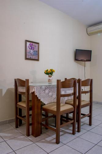 a dining room table with chairs and a television at ΑΚΤΗ ΞΟΒΡΙΟΣ in Kivérion