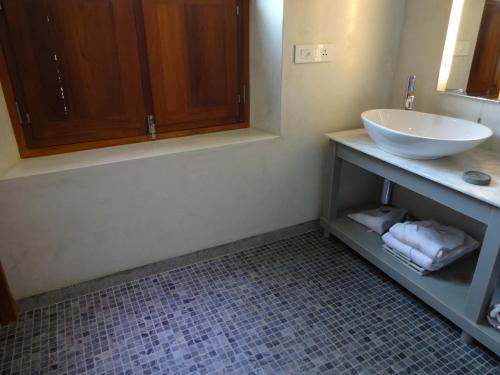 a bathroom with a sink and a counter with towels at La Villa in Puducherry