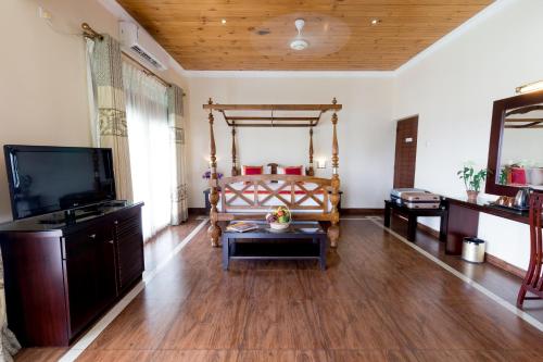 uma sala de estar com uma cama e uma televisão de ecrã plano em Kings Ridge Kandy em Kandy