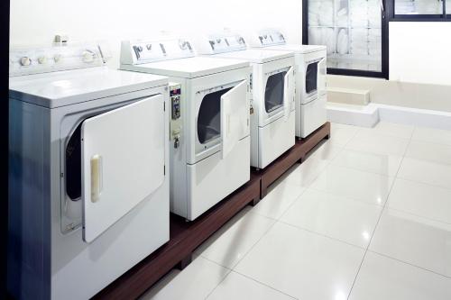 a row of white washers and dryers in a room at The Plimplace Hotel in Bang Su