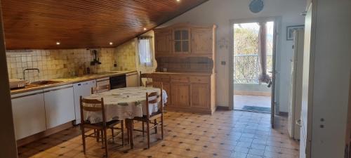 a kitchen with a table and chairs in a room at Charmant T2 in Bastelicaccia