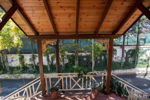 a wooden gazebo with a picnic table under it at Hotel Epidami in Kashari