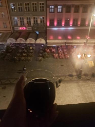 a person taking a picture of a concert at night at Heart of the Old WROCLOVE in Wrocław
