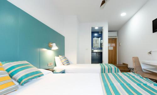 a hotel room with a bed and a desk at Yomo Hostal BCN Port in Barcelona