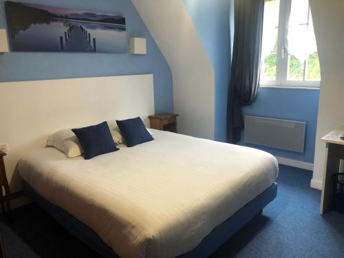 ein Schlafzimmer mit einem großen Bett mit blauen Wänden in der Unterkunft Logis Hotel De La Corniche in Brest