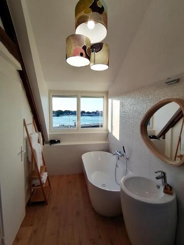 une salle de bain avec une baignoire, un lavabo et un miroir dans l'établissement La Bulle d'Etel, Chambres & Spa, à Étel