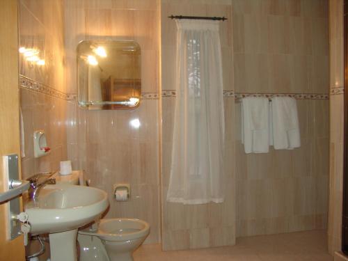 a bathroom with a sink and a toilet and a shower at Eastgate Hotel in Accra