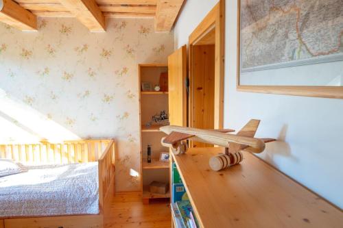 a room with a bed and a wooden table with a toy airplane at Chata u Gregora v Slovenskom raji in Smižany