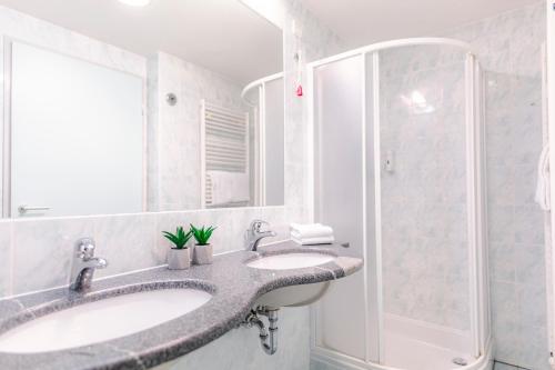 La salle de bains est pourvue de 2 lavabos et d'une douche. dans l'établissement Hotel Čatež - Terme Čatež, à Čatež ob Savi