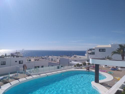 a large swimming pool with a view of the ocean at Apartment Portonovo Paraiso II - Sea View - swimming pool - good Wifi - Old Town in Puerto del Carmen