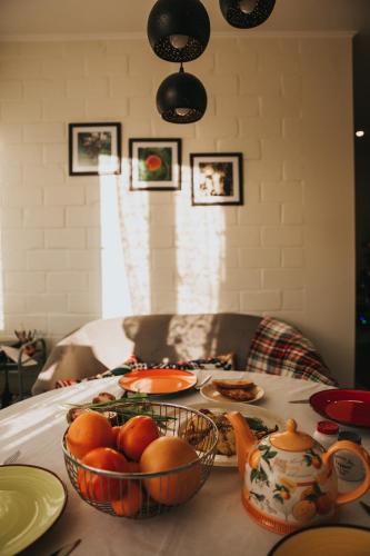 a table with plates and bowls of fruit on it at Guest House Lorem in Daugavpils
